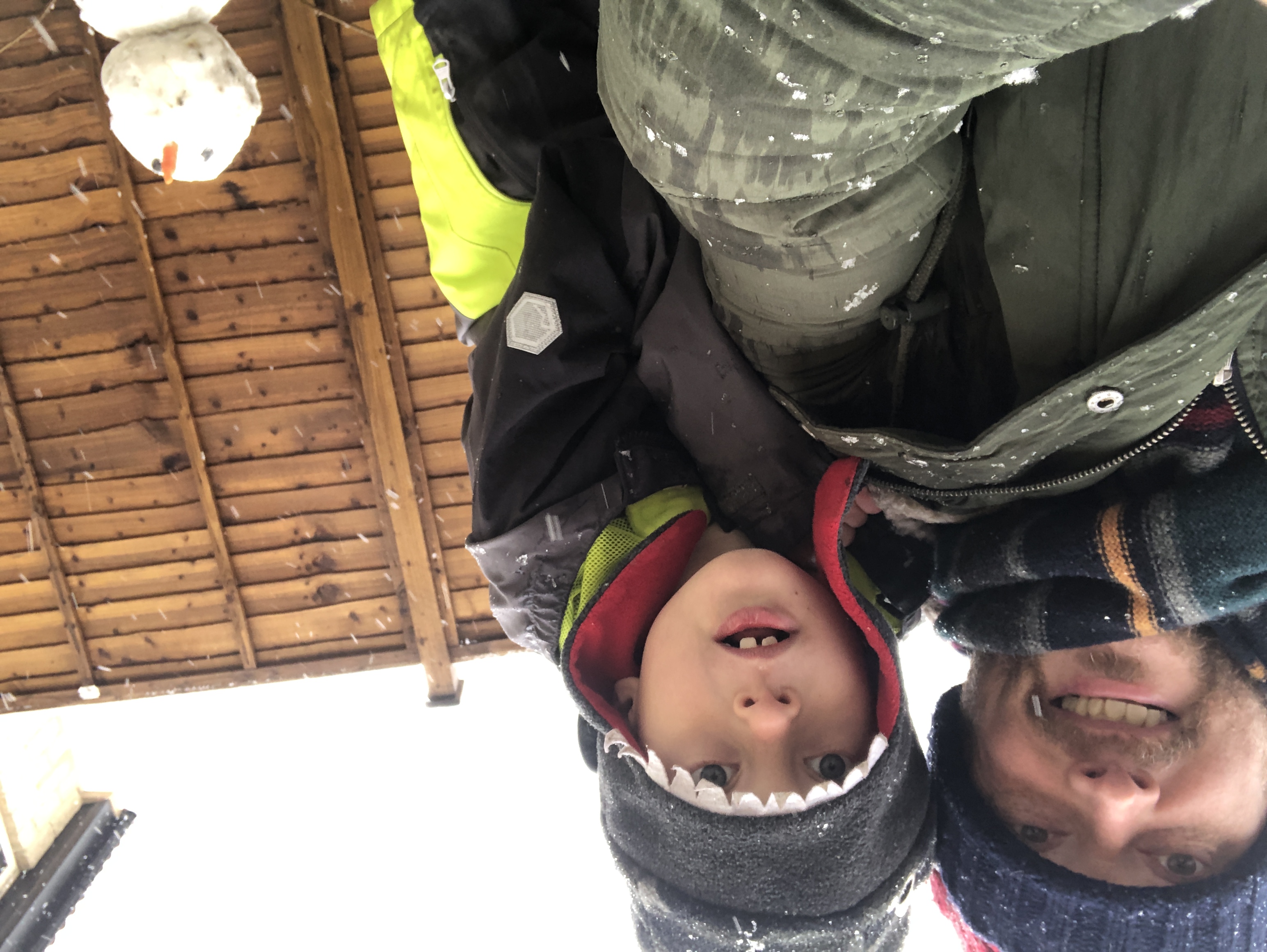 A picture of my son and I building a snowman in our garden